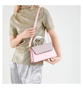 Detail of pink crossbody bag with glitter flap and metallic handle on stylish model