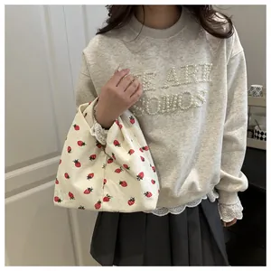 Détail du sac fourre-tout en velours côtelé blanc à imprimé fraises sur mannequin