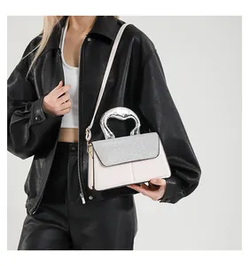 Detail of silver sculptural handle and glitter flap on light pink mini square bag
