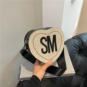 Heart-shaped crossbody bag in cream straw and black leather with SM letter logo