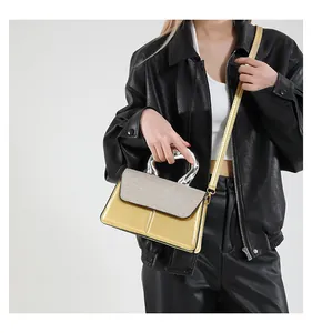 Detail of a chic gold and silver contrast crossbody bag with unique metallic handle