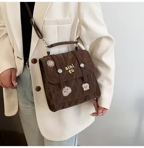 Detail van bruine nylon crossbody tas met retro borduurwerk en verstelbare riem