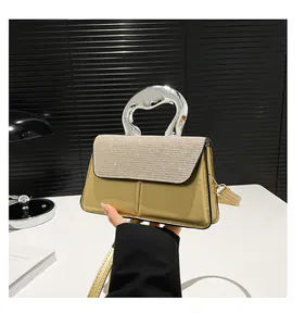 Detail of gold metallic handbag with rhinestone flap and unique silver metal handle