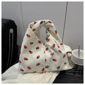 Détail de l'imprimé fraise sur cabas en velours côtelé beige avec anse nouée unique
