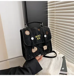 Detailopname van zwarte geplooide tas met berenborduurwerk en zilveren gesp-accent