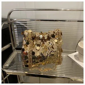 Detailed shot of luxurious gold large sequins and metal chain on a stylish shoulder bag