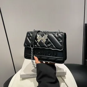 Black quilted crossbody bag with silver butterfly clasp and elegant chain strap