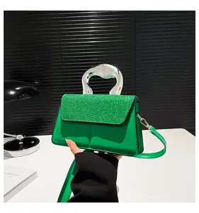 Close-up of vibrant green sequined handbag with unique silver metallic handle and shoulder strap