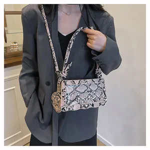 Détail du sac à bandoulière motif serpent rose et noir avec rabat en forme de vague