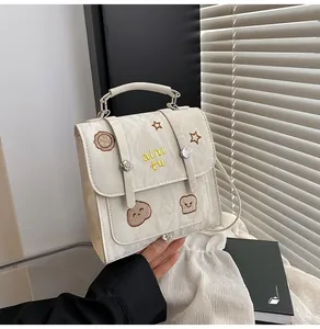 Detail van de crème geplooide tas met schattig toastborduurwerk en unieke textuur
