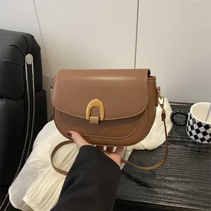 Sacoche selle marron pour femme avec boucle fer à cheval dorée et bandoulière réglable