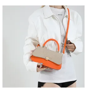 Detailaufnahme einer Damen-Umhängetasche in Orange mit einer beige gewebten Klappe