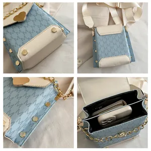 Detail view of mini crossbody phone bag showing bottom studs, hardware, and interior capacity