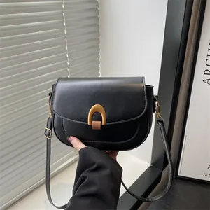 Sacoche noire classique avec boucle dorée en U pour un style urbain élégant