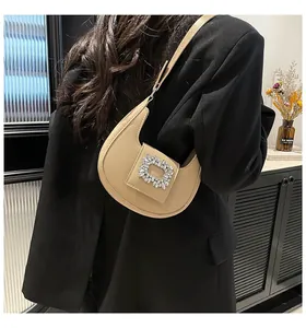 Detail of hobo bag with large sparkling square rhinestone buckle on beige vegan leather