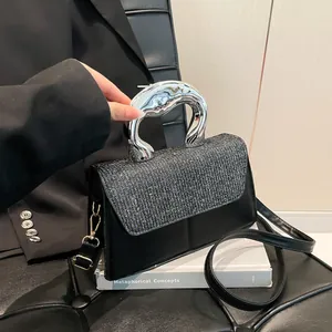 Fashionable black crossbody bag with silver sequined flap and unique metallic handle