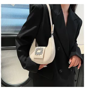 Chic cream-white crescent shoulder bag featuring a sparkling rectangular rhinestone buckle