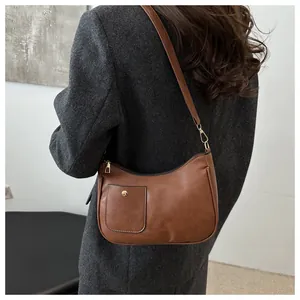 Close-up of brown crescent hobo bag with vintage matte finish and gold hardware details