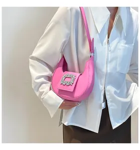 Detailed view of pink leather underarm bag featuring a sparkling rhinestone buckle