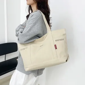 Minimalist cream canvas tote bag with black print and red label, high capacity shoulder bag