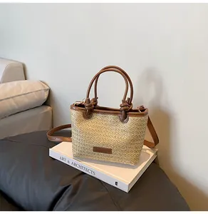 Gros plan du sac de plage tressé avec poignées en cuir nouées et bandoulière amovible
