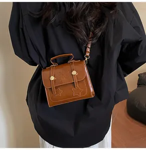 Rear view of model wearing retro brown leather crossbody bag with star details