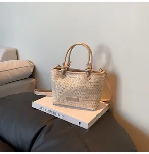 Vue détaillée d'un sac en paille tressée avec anses nouées et bandoulière en cuir