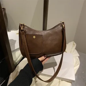 Minimalist brown half-moon shoulder bag in glossy PU leather with gold buckle detail