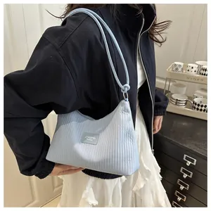 Détail du sac hobo plissé bleu clair avec étiquette de marque JINGPIN en cuir