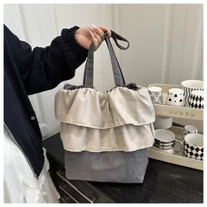 Detail of grey pleated ballet style tote bag with layered ruffle design for daily use
