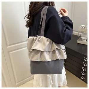 Detail of a chic tote bag featuring multi-layered ruffled design and grey color contrast
