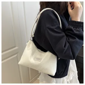 Détail de la texture d'un sac seau en velours blanc avec écusson en cuir JINGPIN