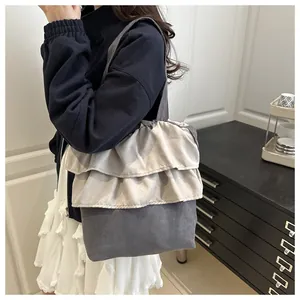 Detail of grey ruffled tote bag with multi-layer pleated design and soft texture finish
