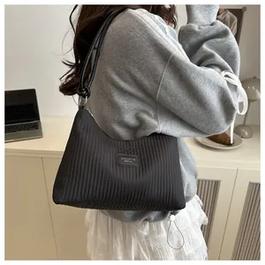Gros plan détaillé d'un sac seau plissé noir avec étiquette en cuir et garnitures argentées