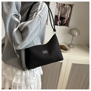 Gros plan détaillé du sac seau plissé noir avec logo métallique et bandoulière