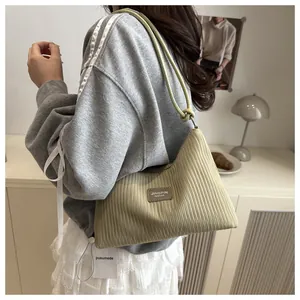 Détail du sac seau plissé avec étiquette en cuir et bandoulière à nœud décoratif