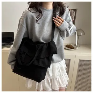 Detail of black canvas tote bag featuring ruffled edges and large capacity for daily use