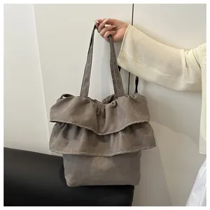 Detail view of the ruffled canvas tote bag featuring layered frill design in dark brown