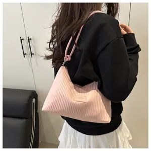 Détail du sac seau plissé rose montrant la texture verticale et la poignée ronde