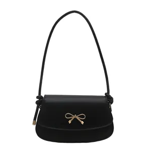 Elegant black underarm bag for women with a gold bow buckle and smooth leather texture