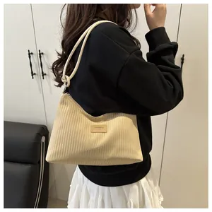 Détail du sac bandoulière en velours côtelé beige avec étiquette cuir JINGPIN