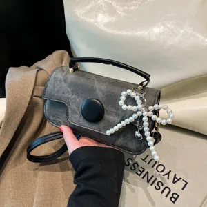 Contrast color rectangular handbag with denim texture and pearl bow charm accessory