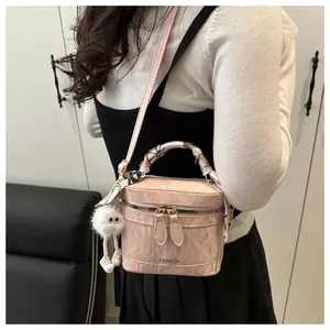 Detail of pink pleated mini bucket bag with silk scarf handle and cute pompom charm