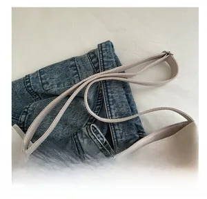 Dettaglio borsa tote beige con volant, spalline sottili e minuterie metalliche argentate