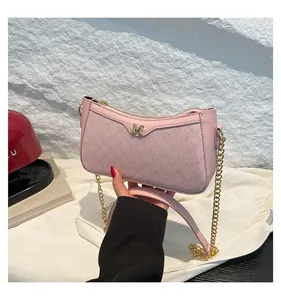 Detailed view of pink shoulder bag with textured fabric and gold metal M letter logo