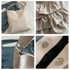 Dettagli dei livelli di volant e chiusura magnetica sulla borsa a tracolla beige