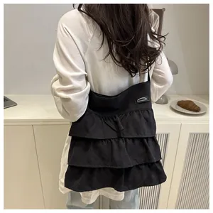 Dettaglio della borsa a tracolla nera con volant che mostra la texture e il design morbido