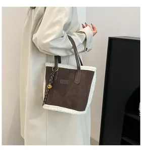 Detail der Wildleder-Tasche mit weichem Plüschbesatz und goldenem Glockenanhänger