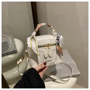 Detail view of marble-textured bucket bag with silk scarf handle and golden hardware
