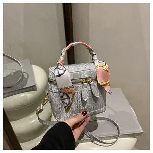 Detail of grey marble bucket bag with fashion print and silk scarf handle decor